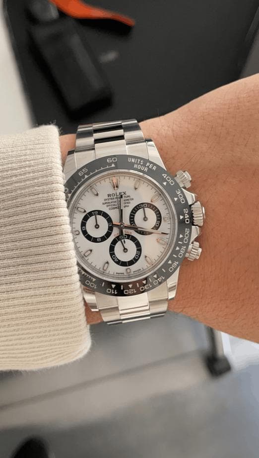 Wrist shot of a steel Rolex Daytona chronograph with a white dial and black ceramic bezel